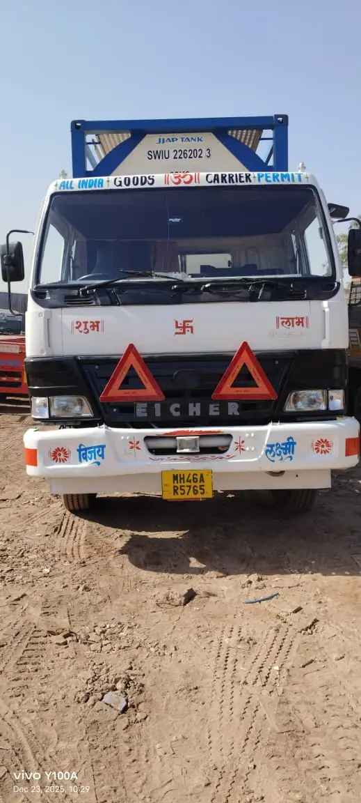 Front view of a white truck with an ISO tank frame visible above the cab