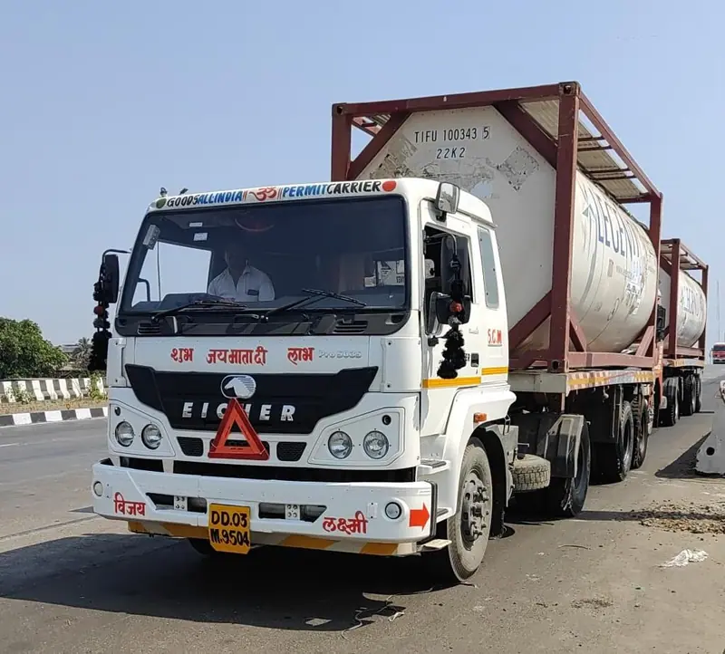 White tractor carrying an ISO tank container on a highway