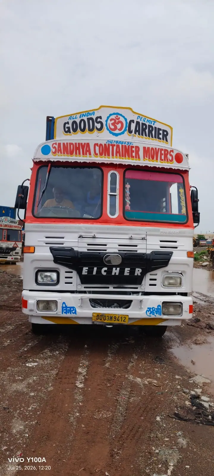 Front of a Sandhya Container Movers truck on a muddy yard