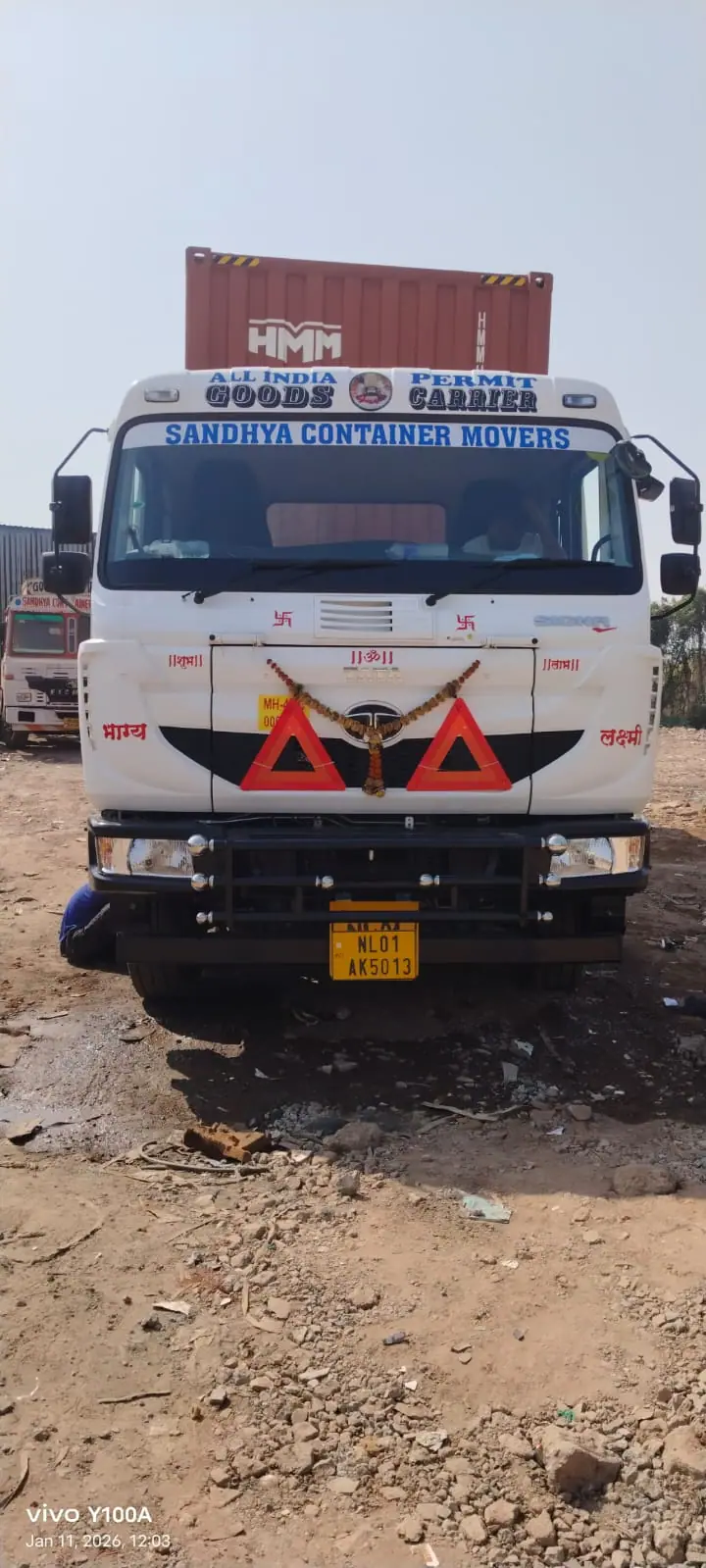 Front of a Sandhya truck carrying a container