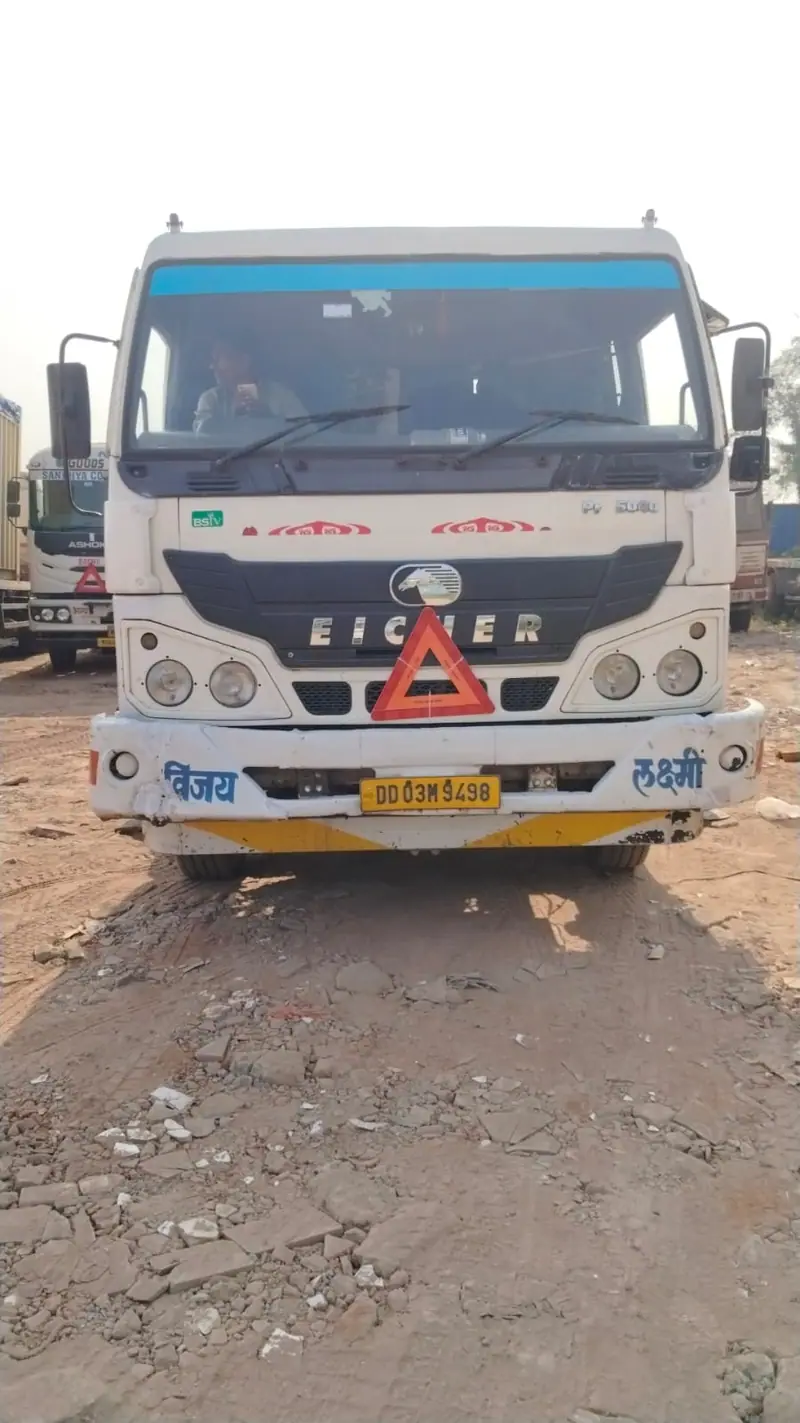Front of a white truck parked on gravel